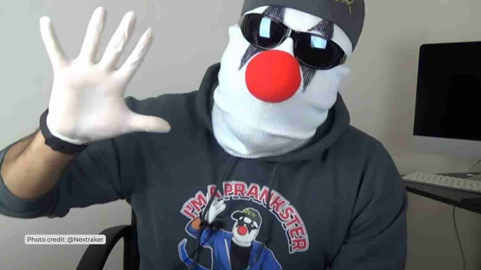 Masked clown waving hello