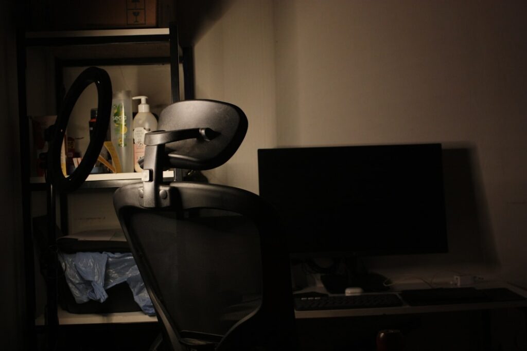 Desk with chair and computer in dim lighting