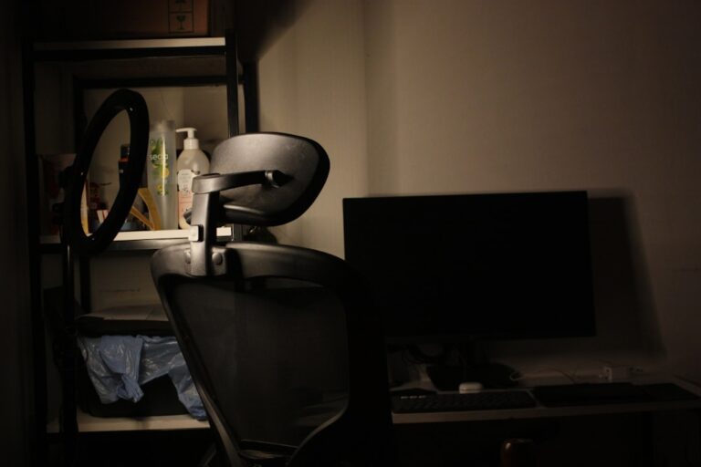 Desk with chair and computer in dim lighting