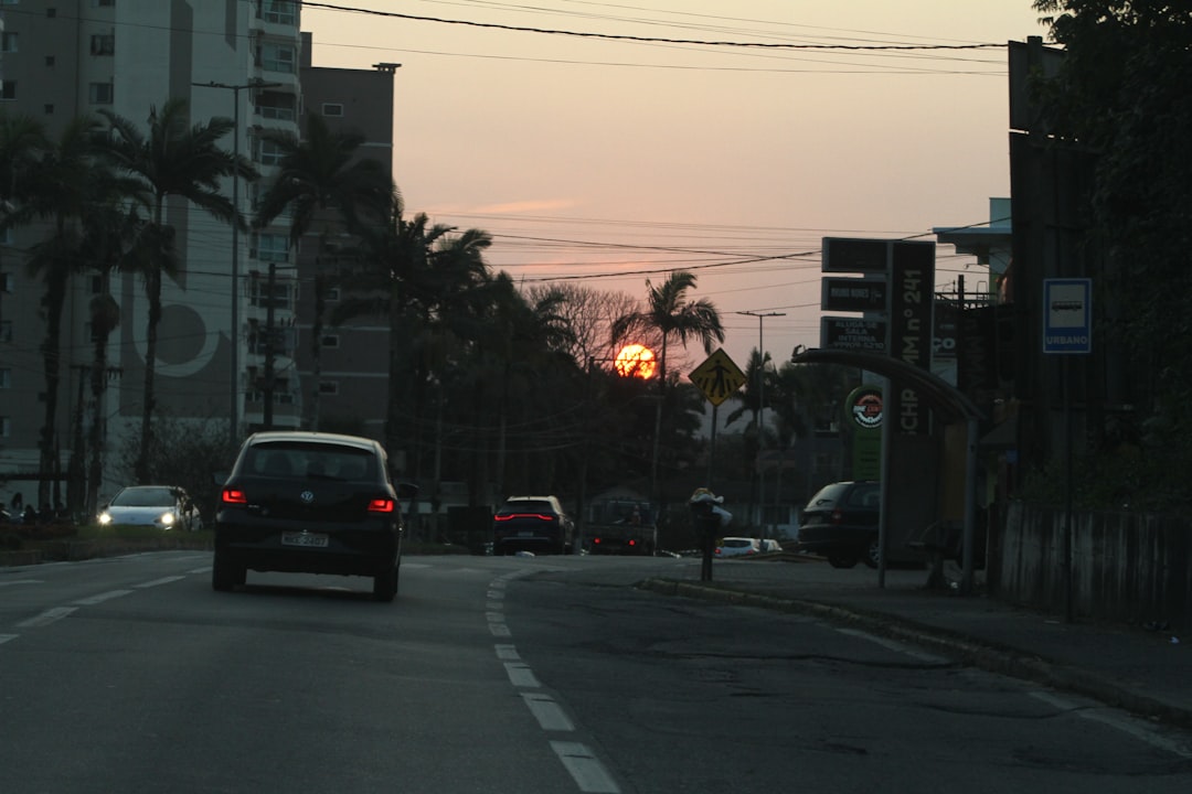 A car driving down a street next to tall buildings